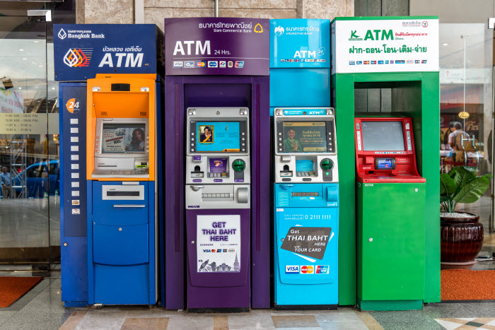банкоматы тайских банков в ряд - банки Таиланда используют отличительные фирменные цвета и оттенки